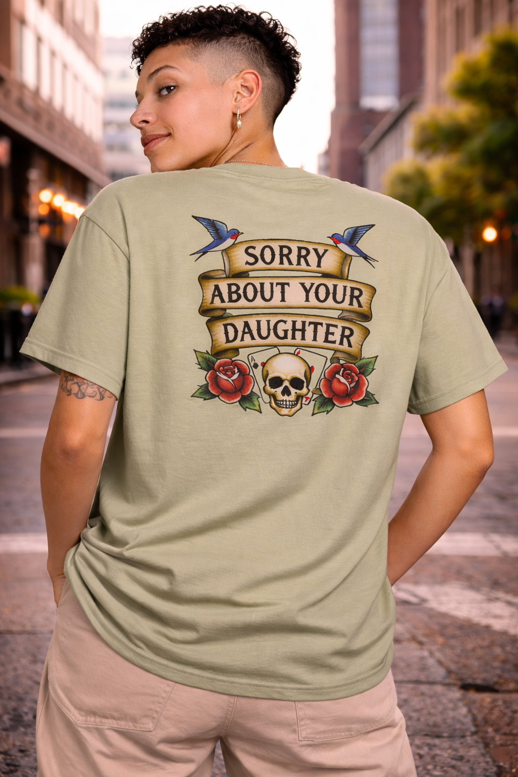 Person wearing a green t-shirt with a graphic design on the back in an urban setting.
