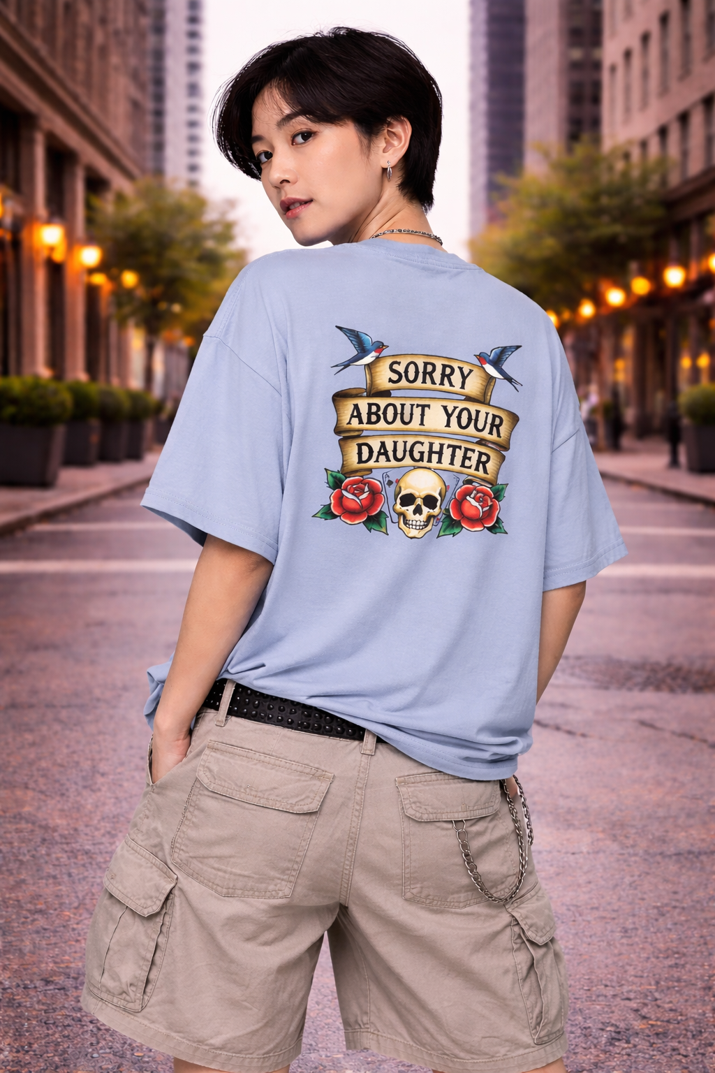 Person wearing a light blue t-shirt with a graphic design on the back in an urban setting.
