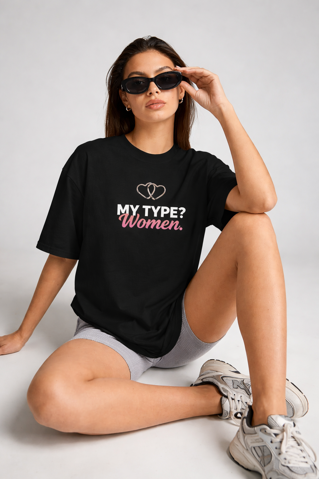 Woman wearing a black t-shirt with text, sitting on a light gray background