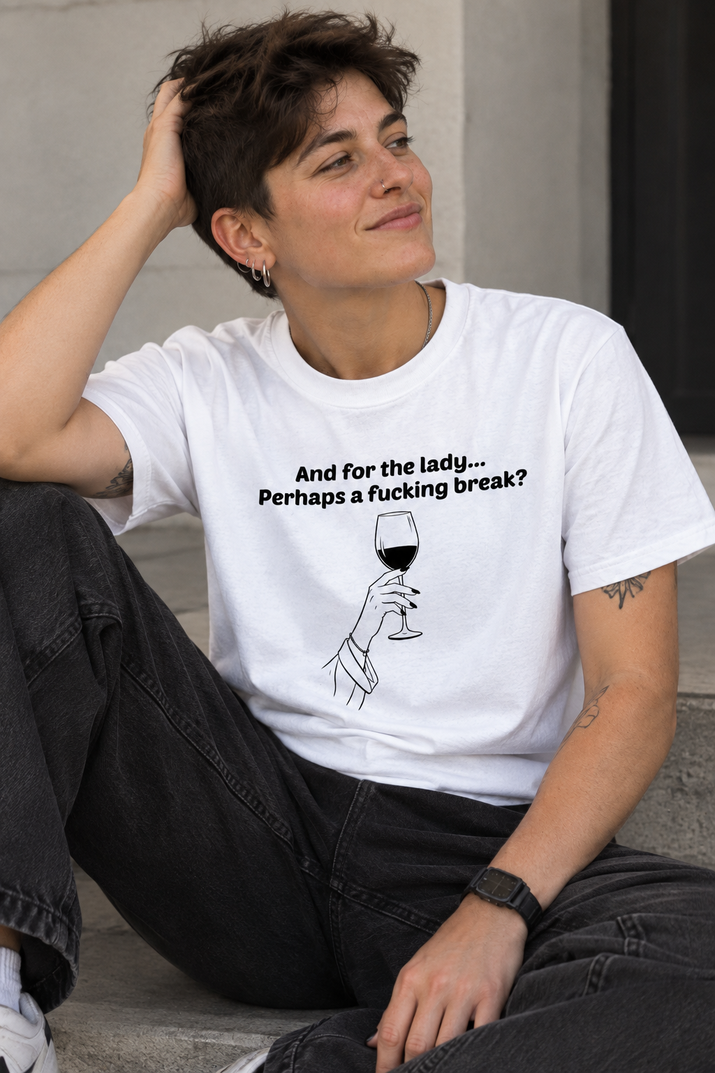 A person wearing a white graphic T-shirt with black text reading 'And for the lady