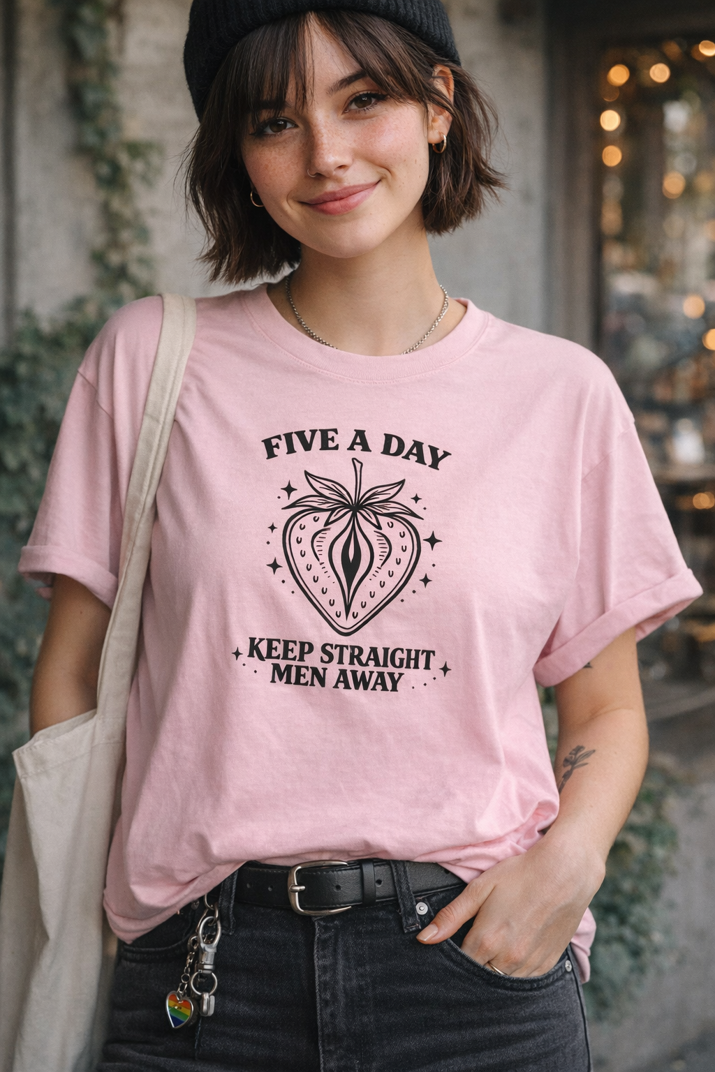 Person wearing a pink t-shirt with a graphic design and text.