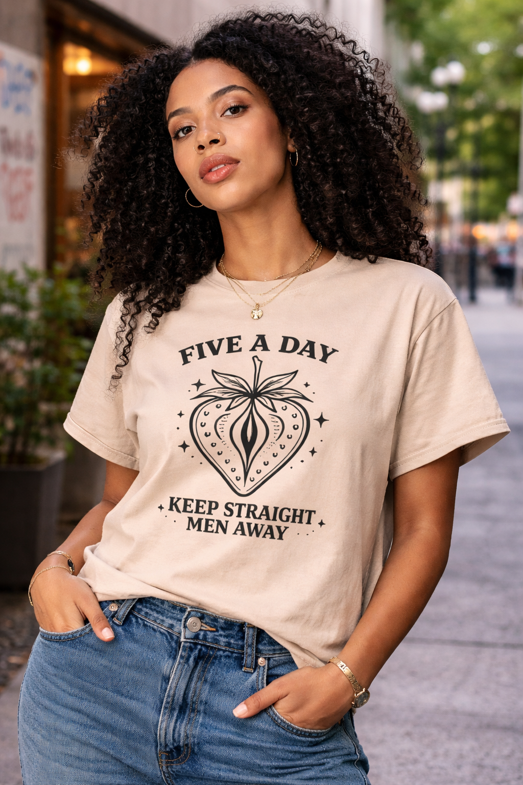 Woman wearing a t-shirt with a graphic design and text on a city street.
