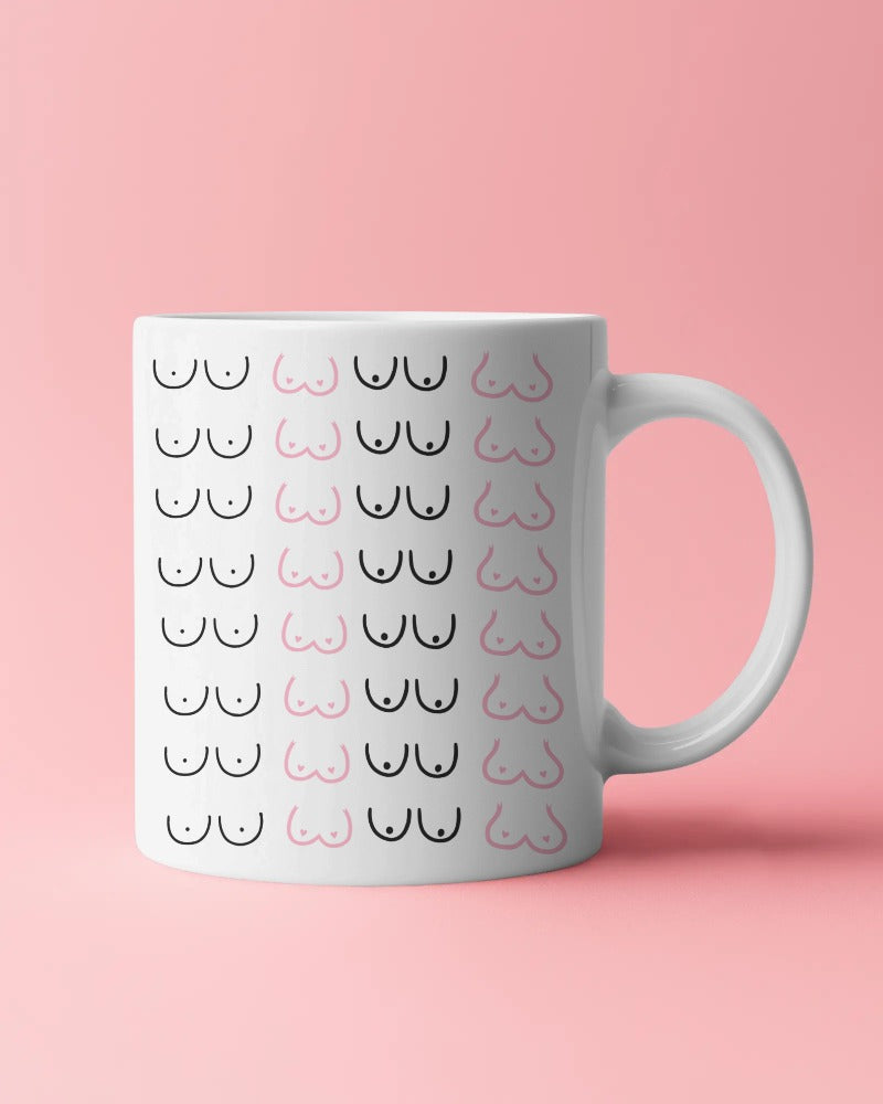 Ceramic mug with minimalist boob print by Savage Cotton, styled on a kitchen counter with coffee and pastel decor