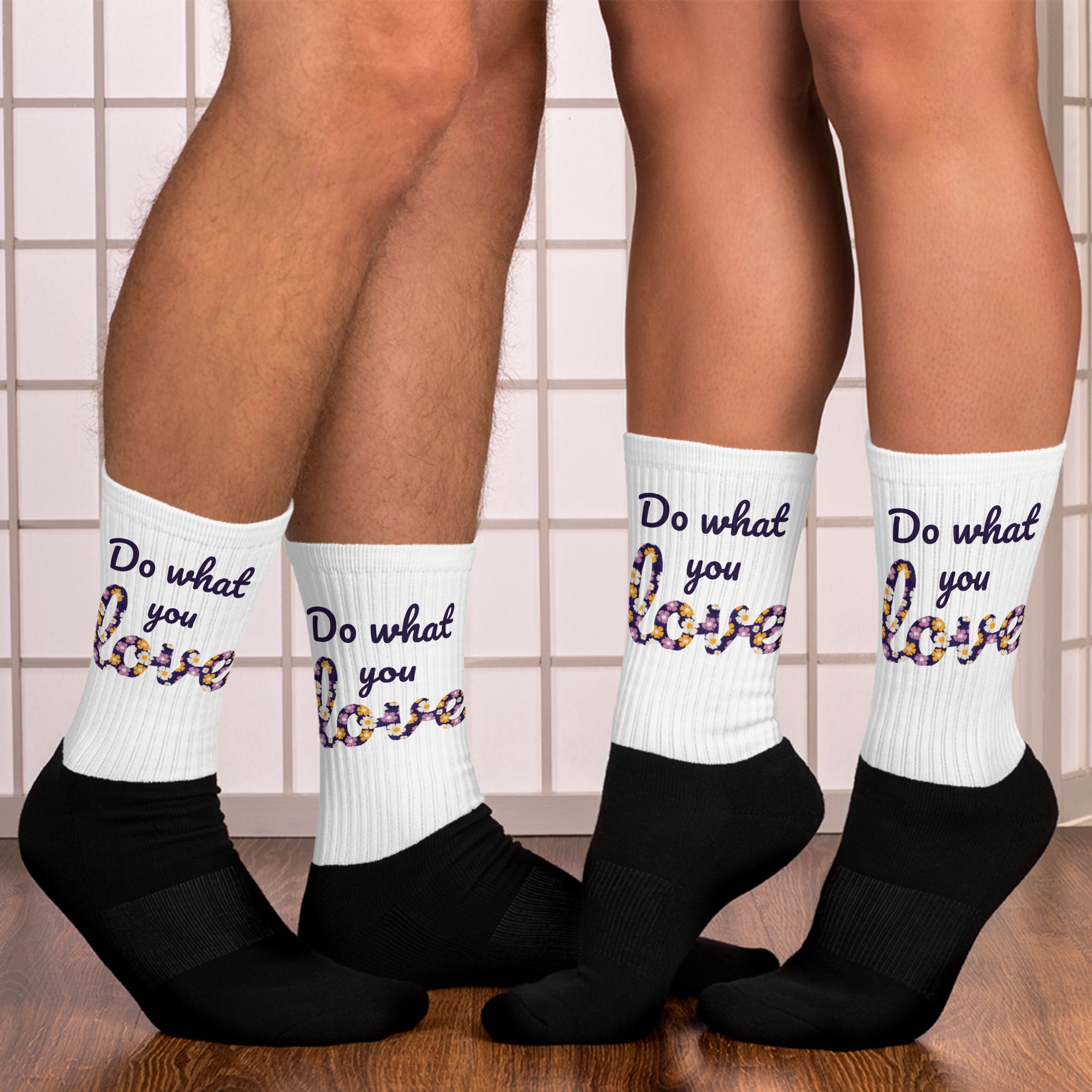 White socks with 'Do what you love' text worn by two people on a tiled floor.