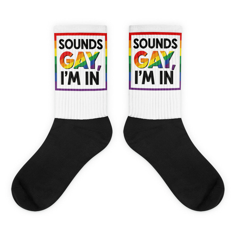 Pair of socks with 'Sounds Gay, I'm In' text and rainbow colors on a white background