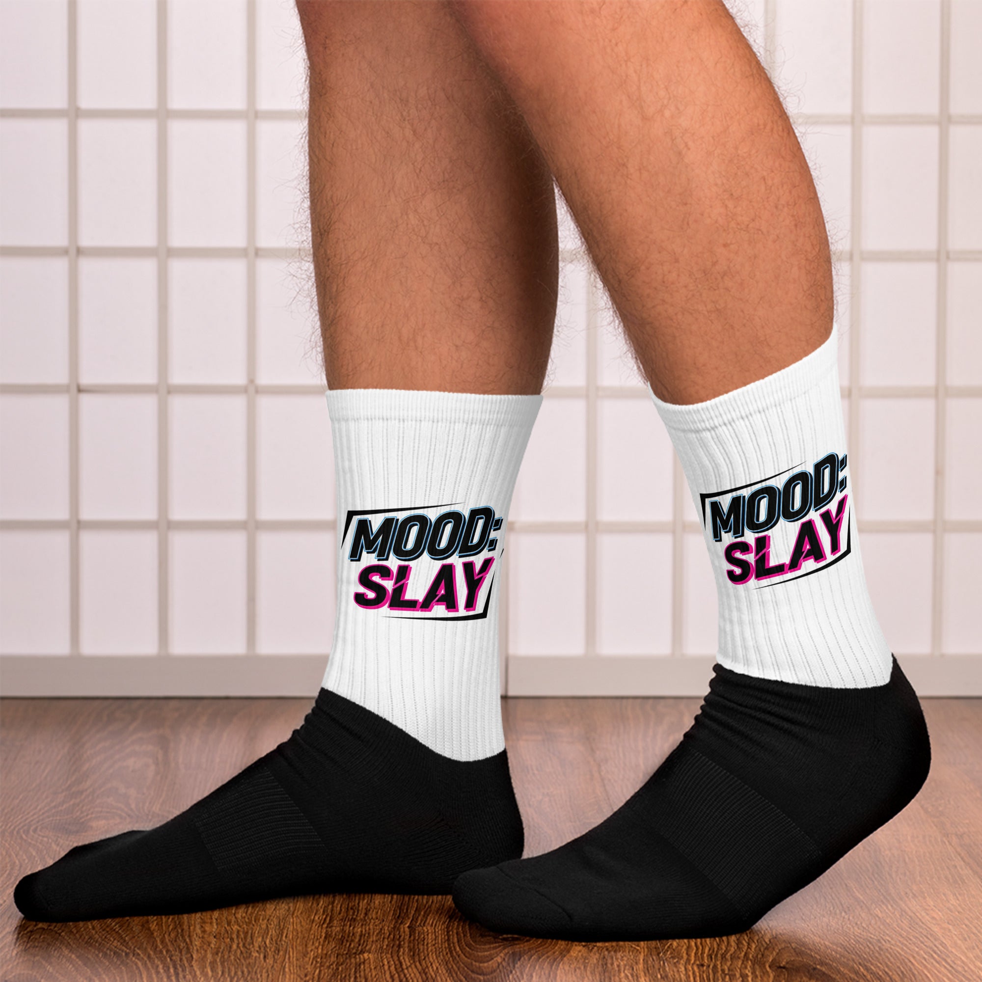 White socks with 'MOOD SLAY' text worn by a person on a tiled floor.