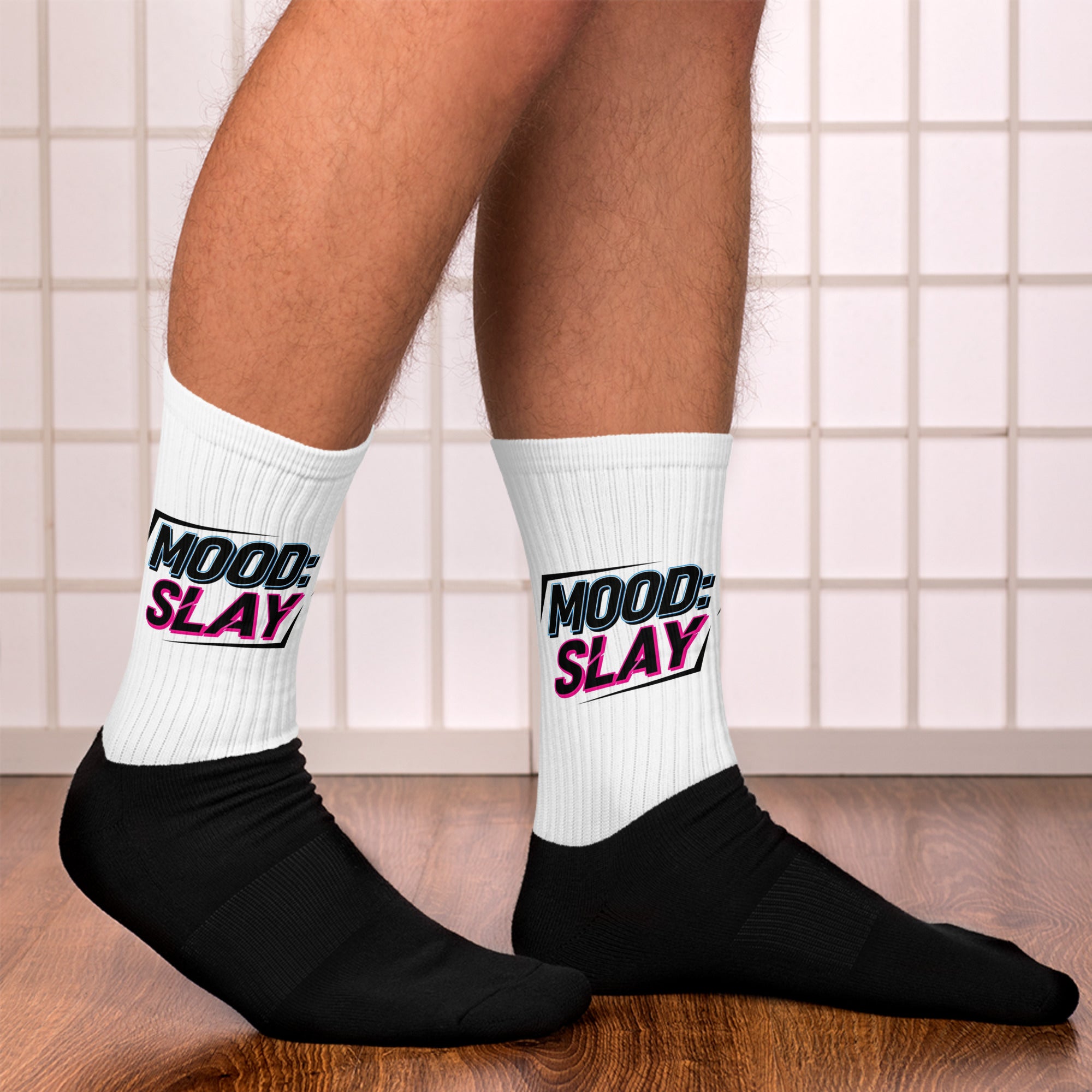White socks with 'Mood Slay' text worn by a person on a tiled bathroom floor.