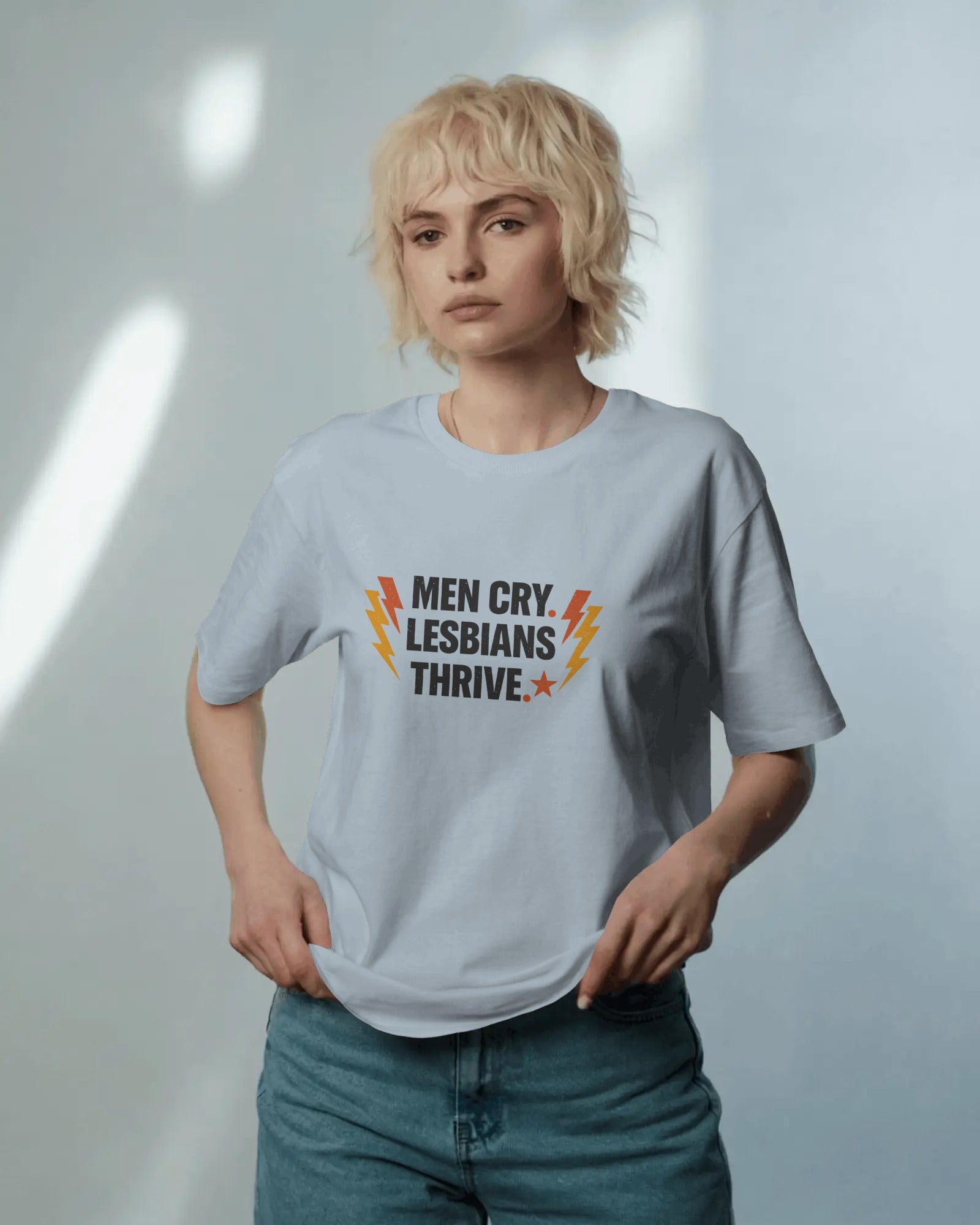 Men Cry, Lesbians Thrive slogan printed on a unisex t-shirt with bold typography on a neutral background