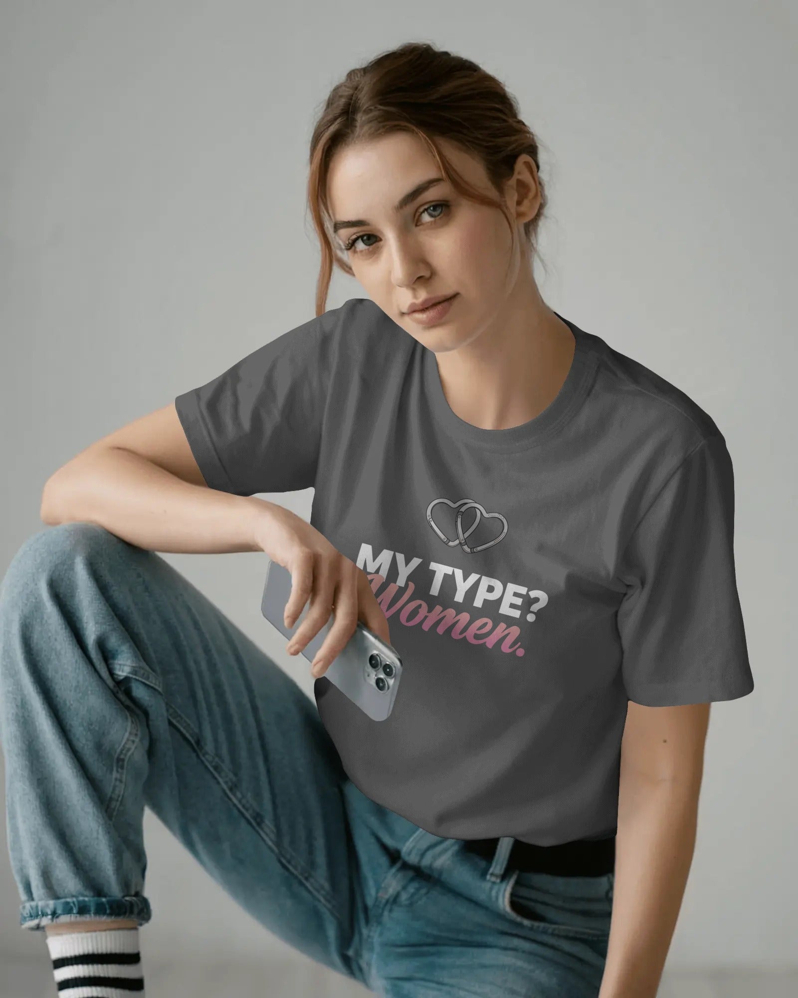 Person wearing a gray t-shirt with text and sitting on the floor.