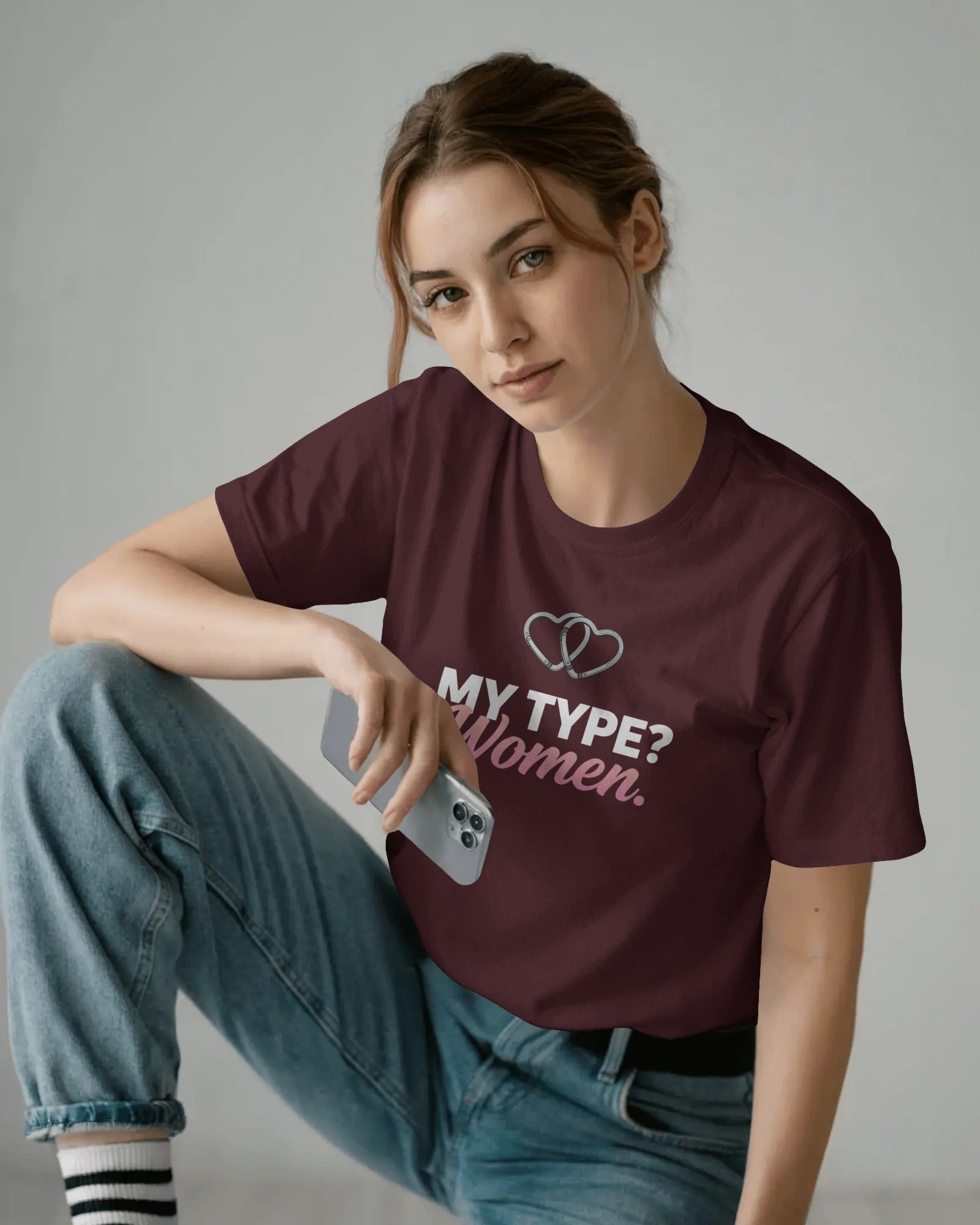 Person wearing a maroon t-shirt with text and sitting on the floor.