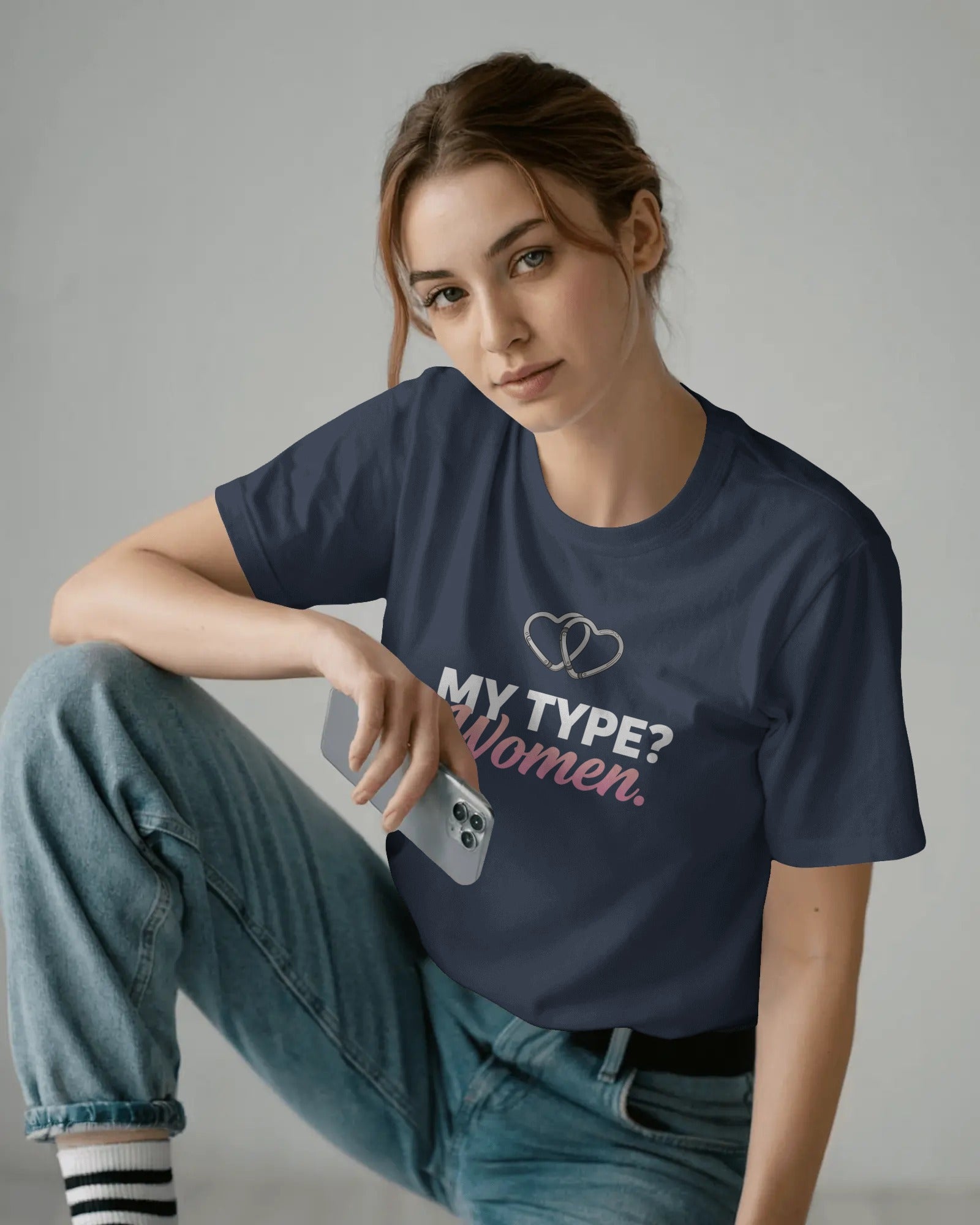 Person wearing a navy blue t-shirt with text and sitting on the floor.