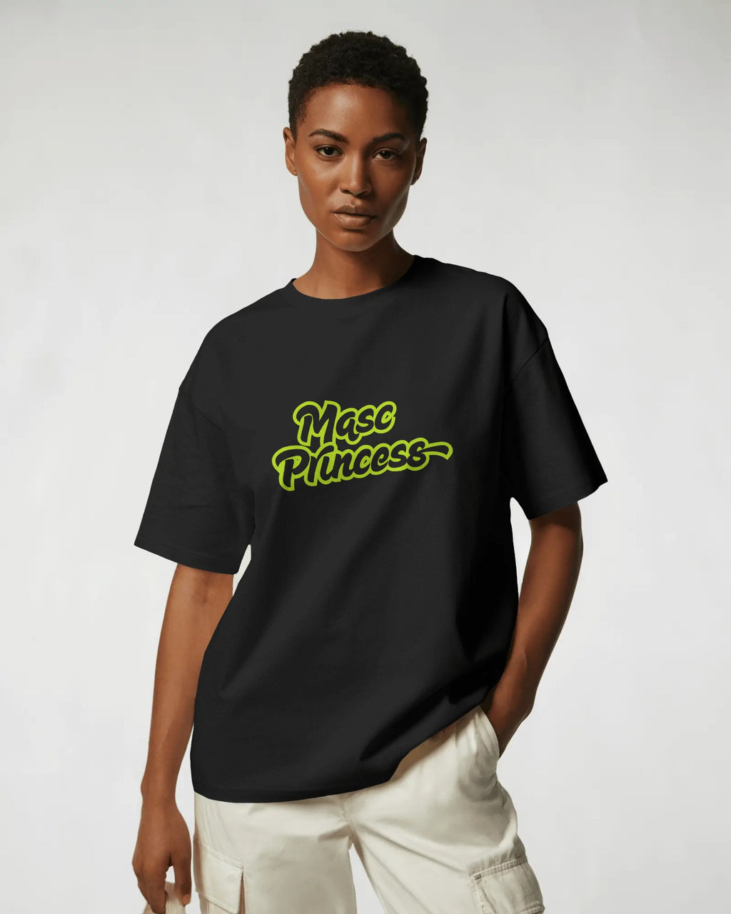 Female model wearing black Masc Princess oversized t-shirt with neon green slogan, styled with ripped jeans and sunglasses, queer streetwear fashion