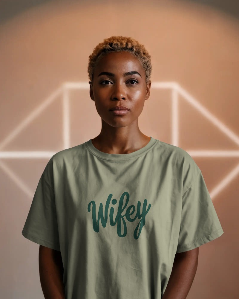 Person wearing a green t-shirt with 'Wifey' text against a geometric-patterned background
