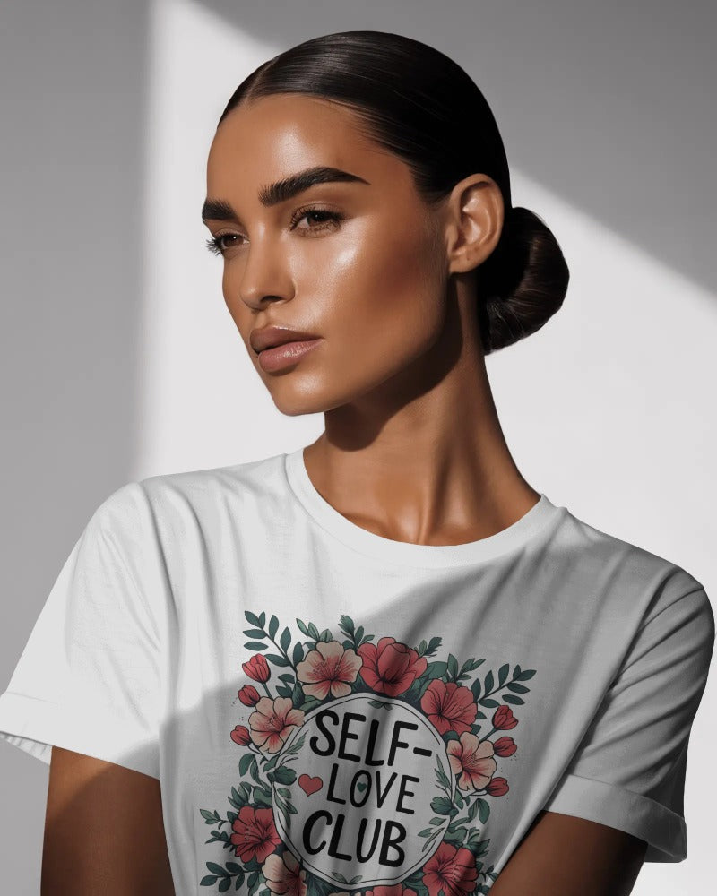 Woman wearing a "Love Yourself First" T-shirt in soft cotton, smiling confidently outdoors.