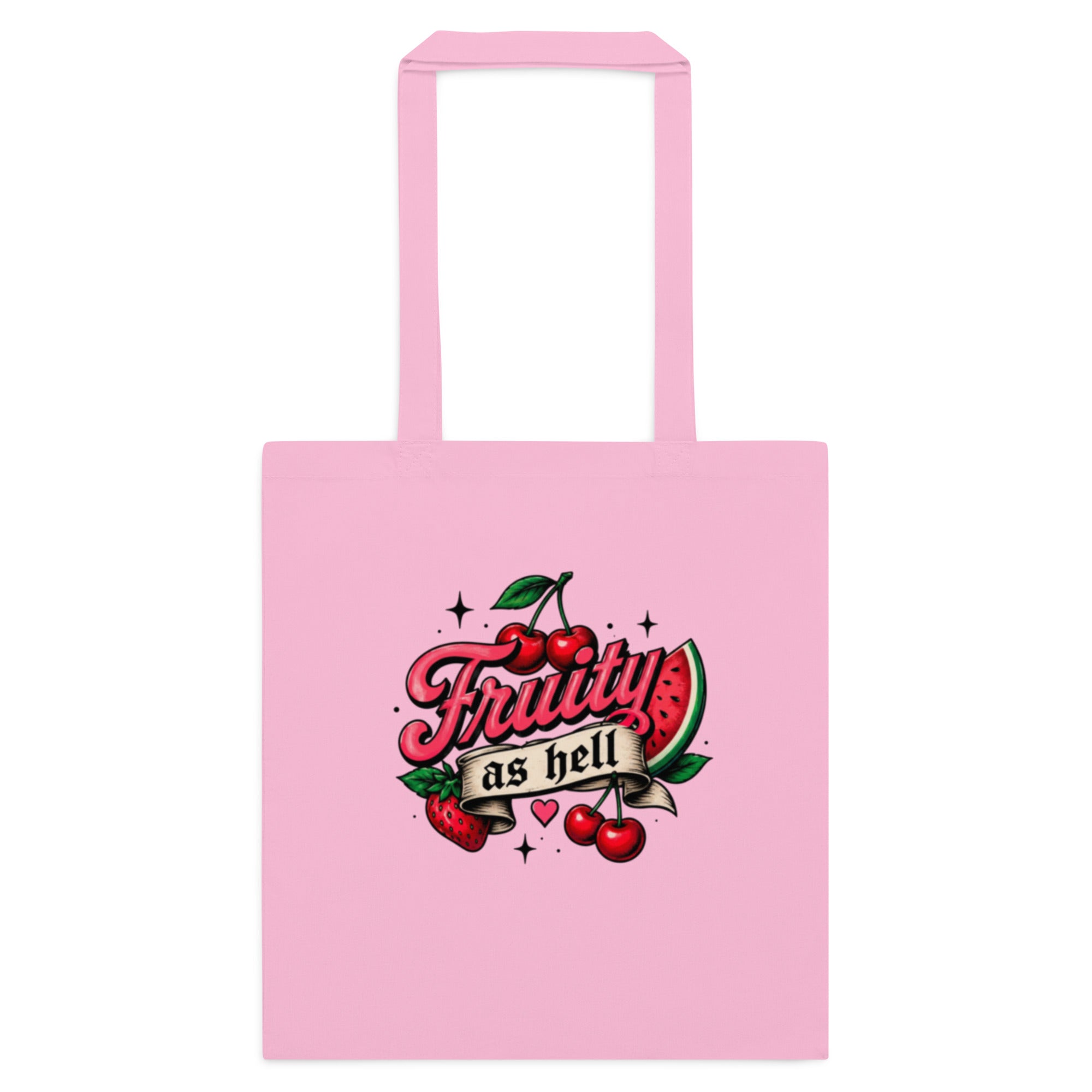 A light pink canvas tote bag with two top handles, featuring a retro-style graphic on the front that reads 'Fruity as hell' in red script, decorated with cherries, a watermelon slice, and small stars.