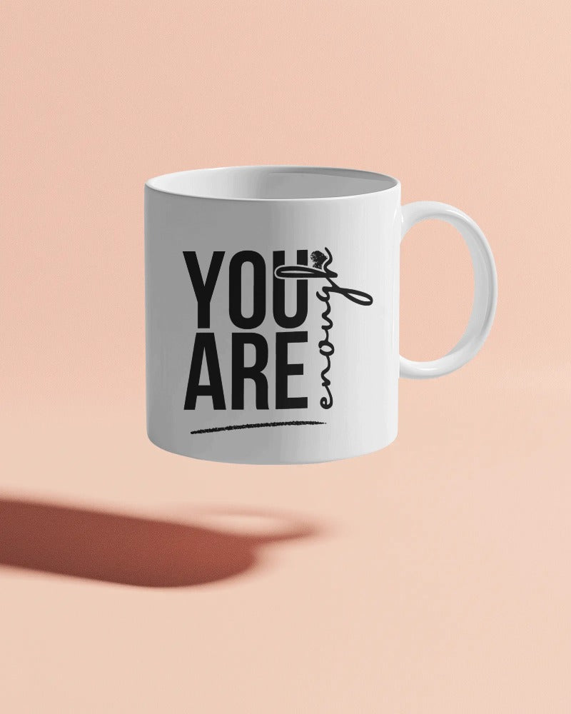 “White ceramic mug with bold black text reading ‘You Are Enough’”