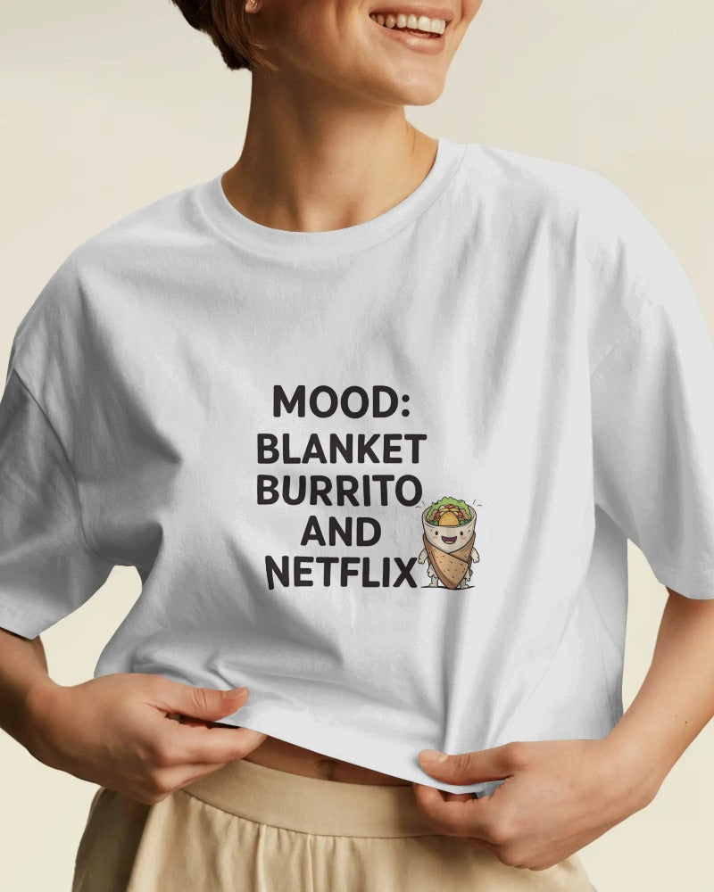 Person wearing a white t-shirt with text and graphic design on a beige background