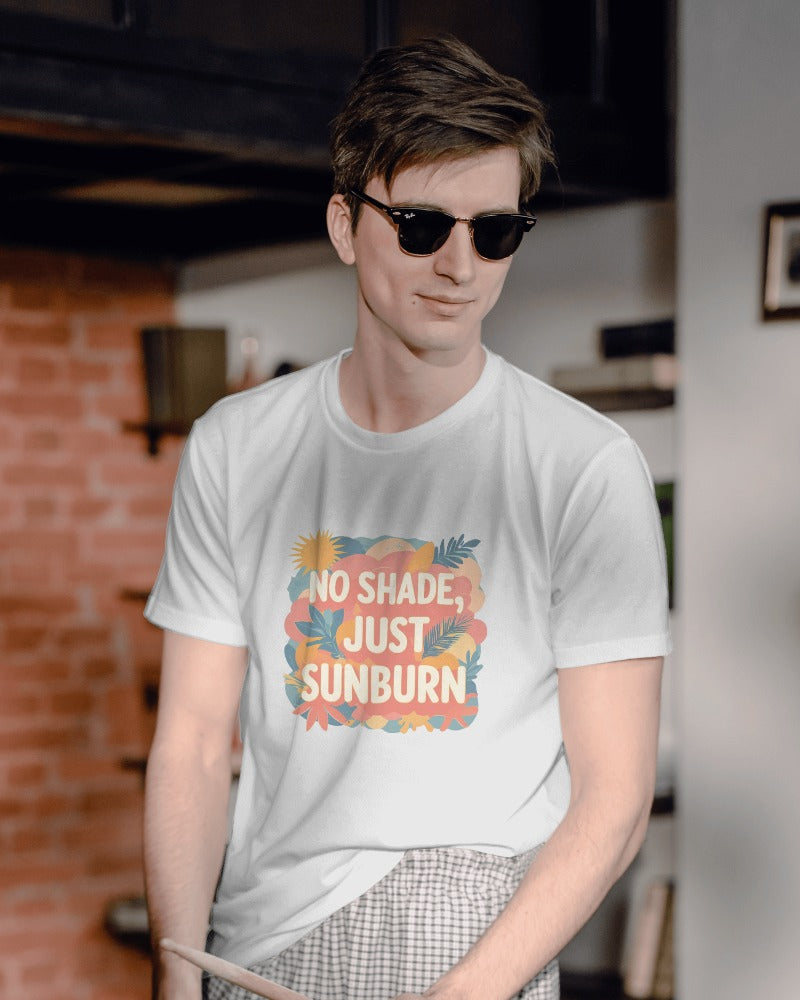 Person wearing a white t-shirt with 'No Shade, Just Sunburn' text and sunglasses indoors.