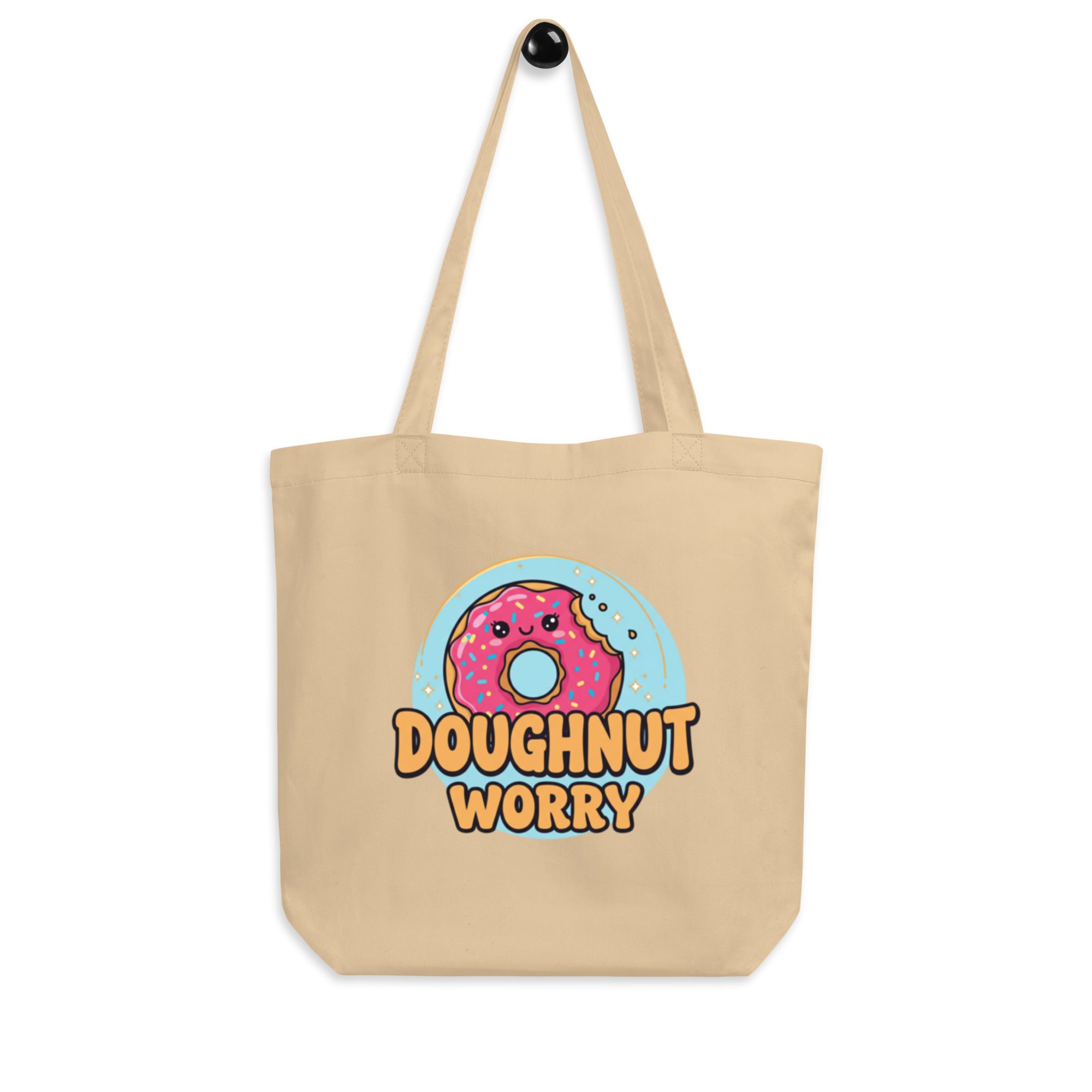 Beige tote bag with a kawaii donut graphic and 'Doughnut Worry' text on a white background