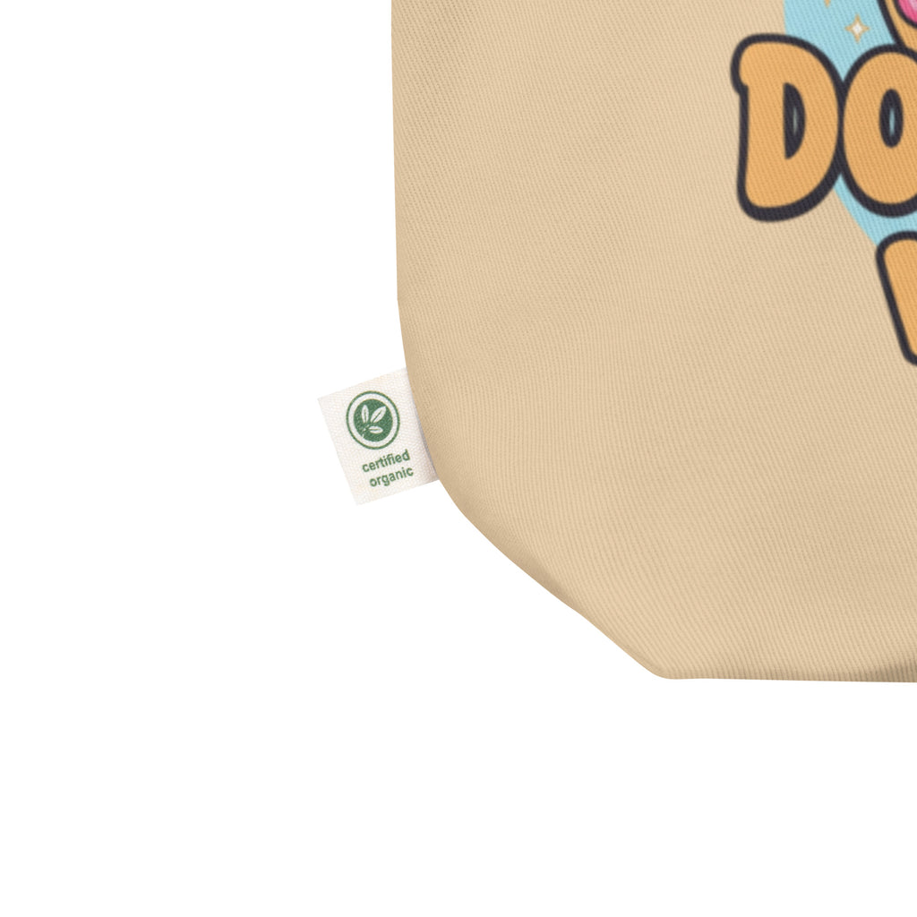 Beige tote bag with a cartoon character and a 'certified organic' tag.