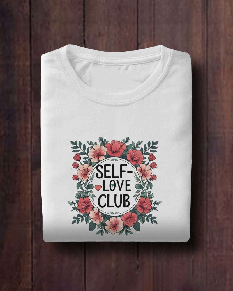 Woman wearing a "Love Yourself First" T-shirt in soft cotton, smiling confidently outdoors.