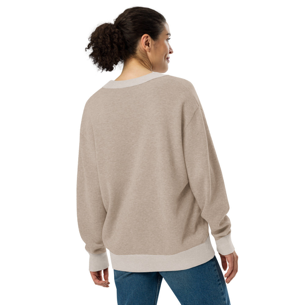 Woman wearing a beige sweater and blue jeans on a white background