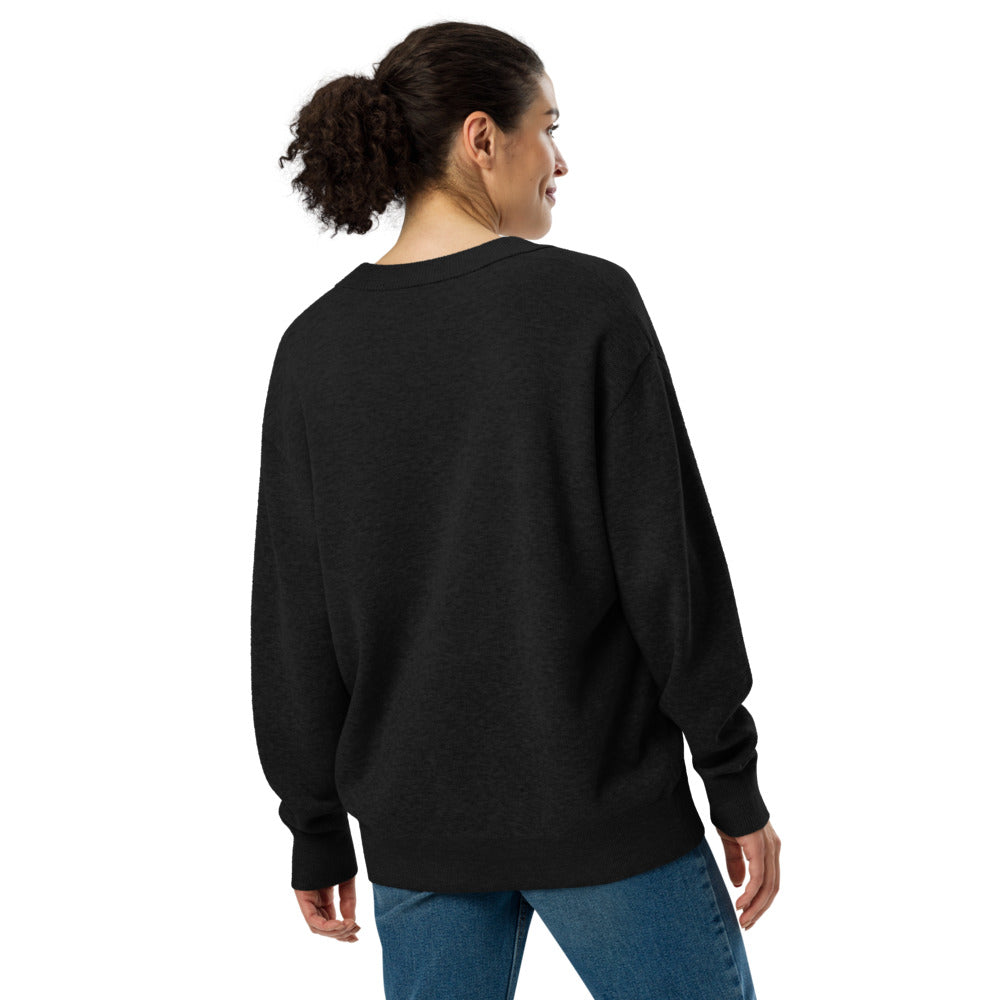 Person wearing a black sweatshirt and blue jeans on a white background