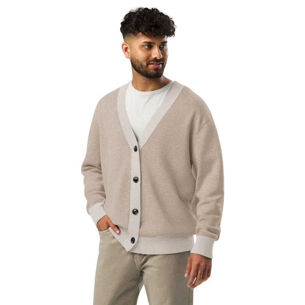 Man wearing a beige cardigan over a white shirt with beige pants on a white background