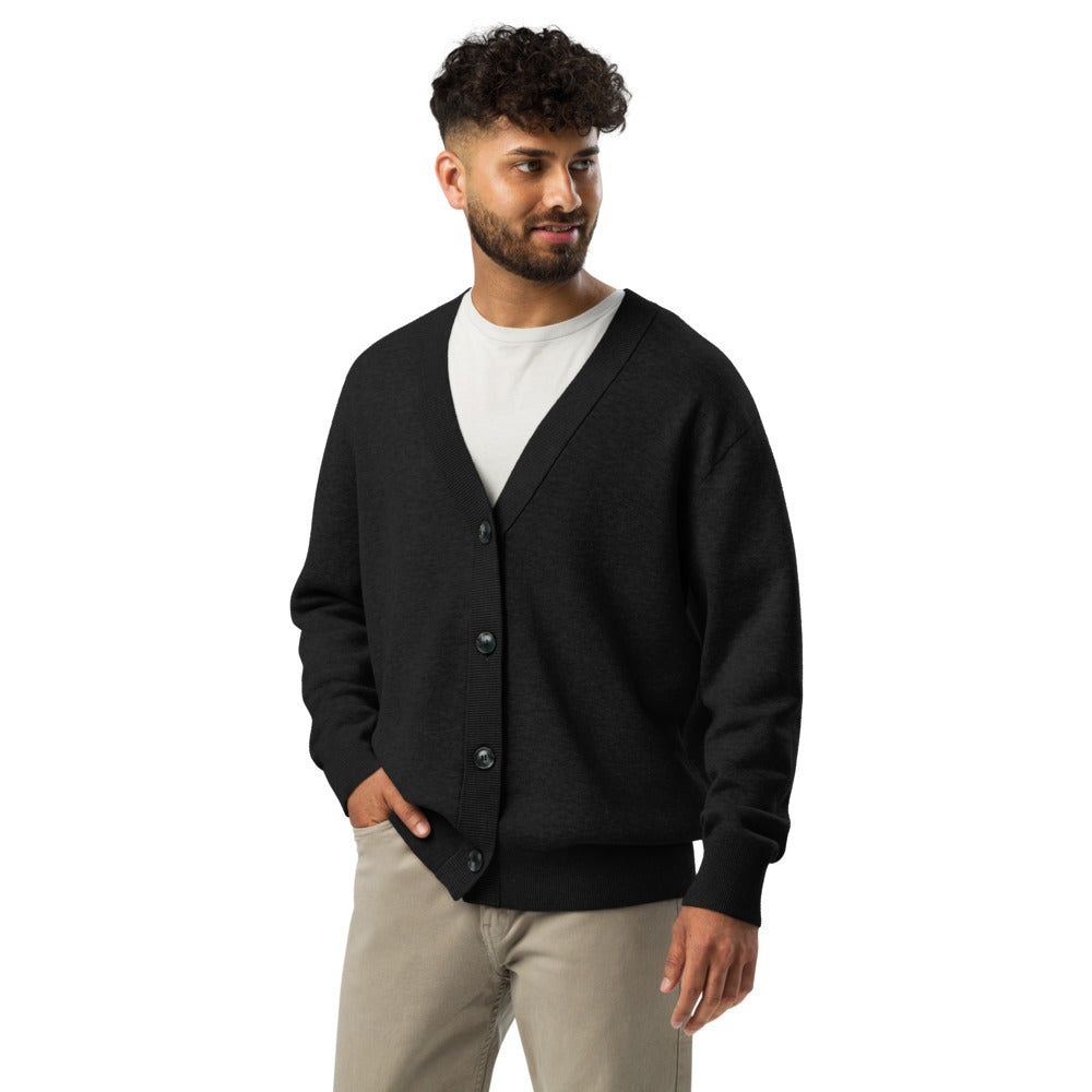 Man wearing a black cardigan over a white shirt on a white background