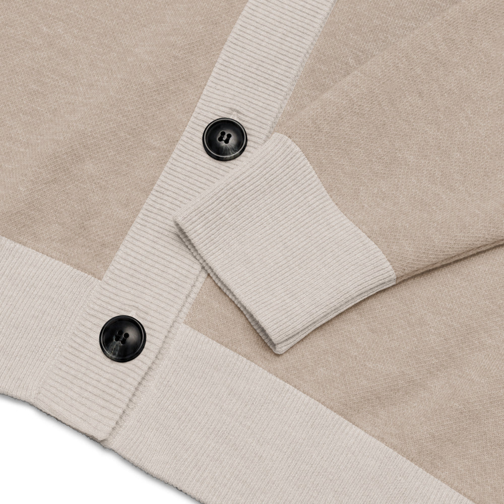 Close-up of a beige and white textured fabric with black buttons on a matching background