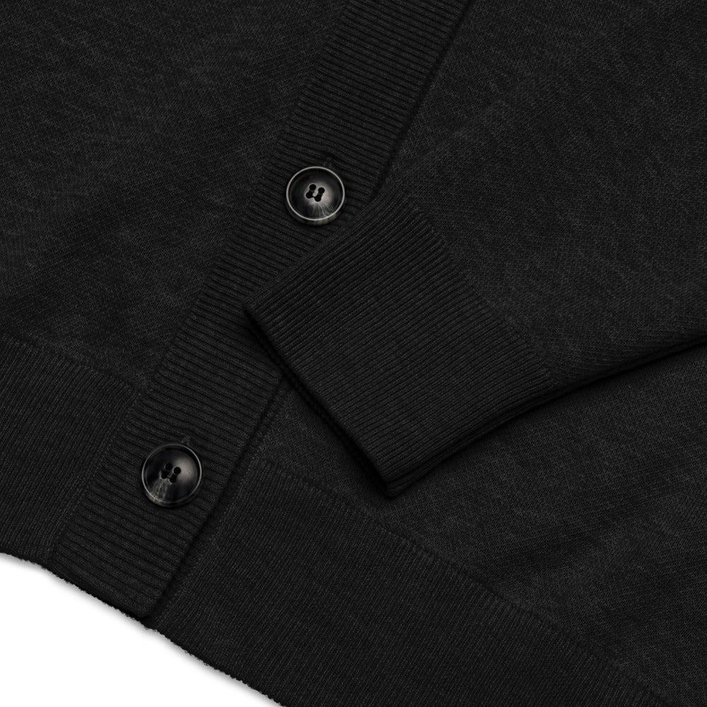 Close-up of a black cardigan with buttons on a white background