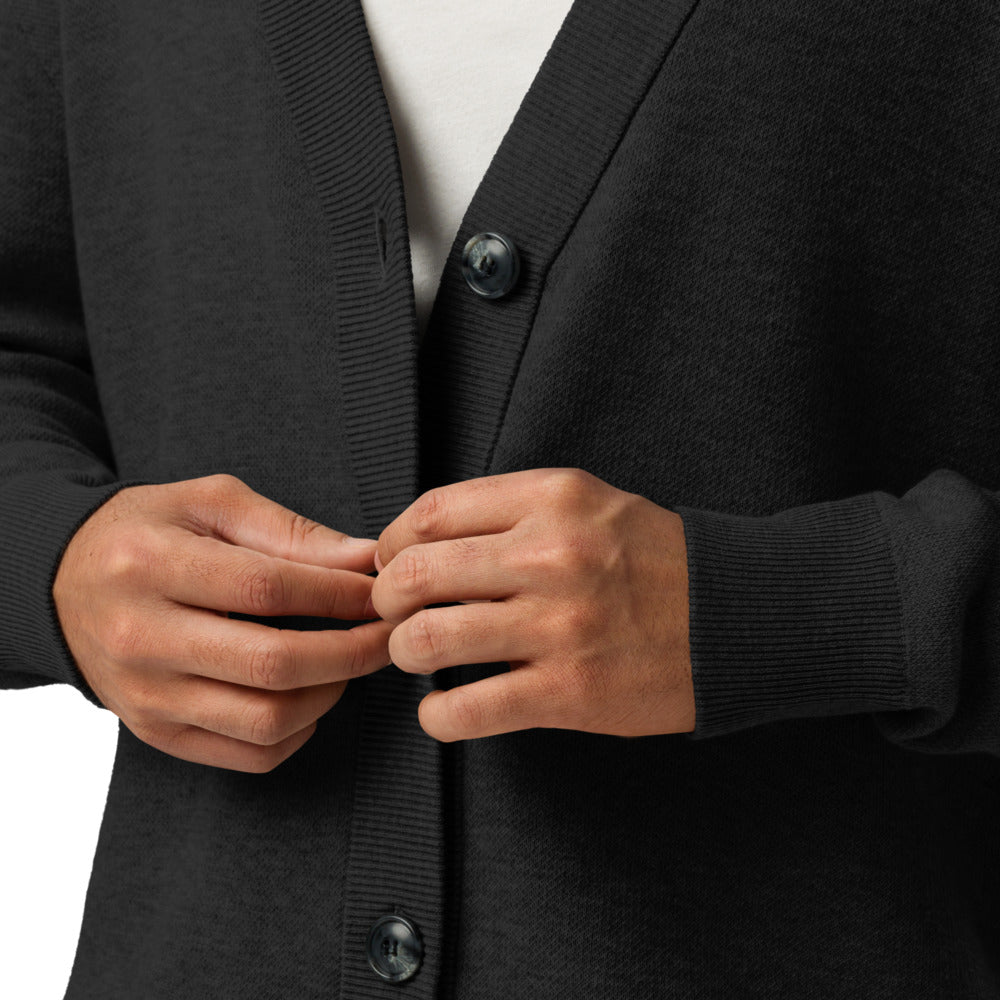 Person wearing a dark gray cardigan buttoning it up with a white shirt underneath.