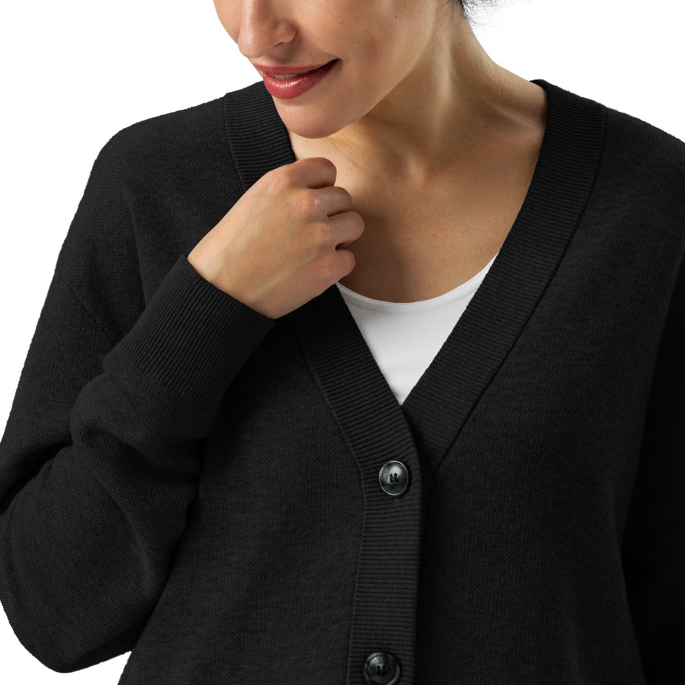 Person wearing a black cardigan over a white shirt on a white background