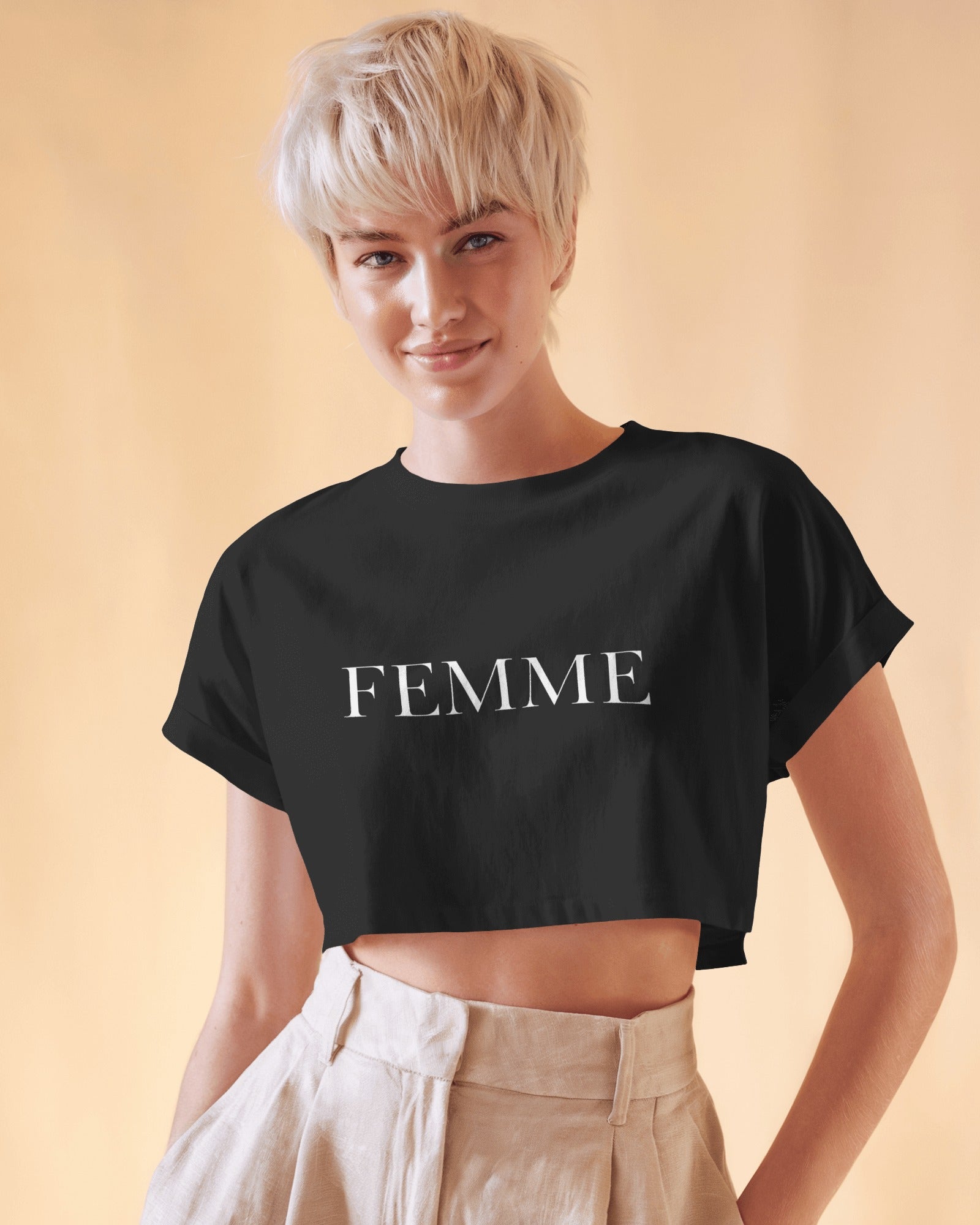 Queer femme model wearing a white FEMME crop top, minimal bold typography