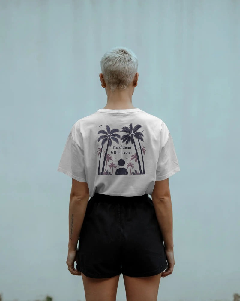 Person wearing a white t-shirt with a graphic design on the back, standing against a light blue background.