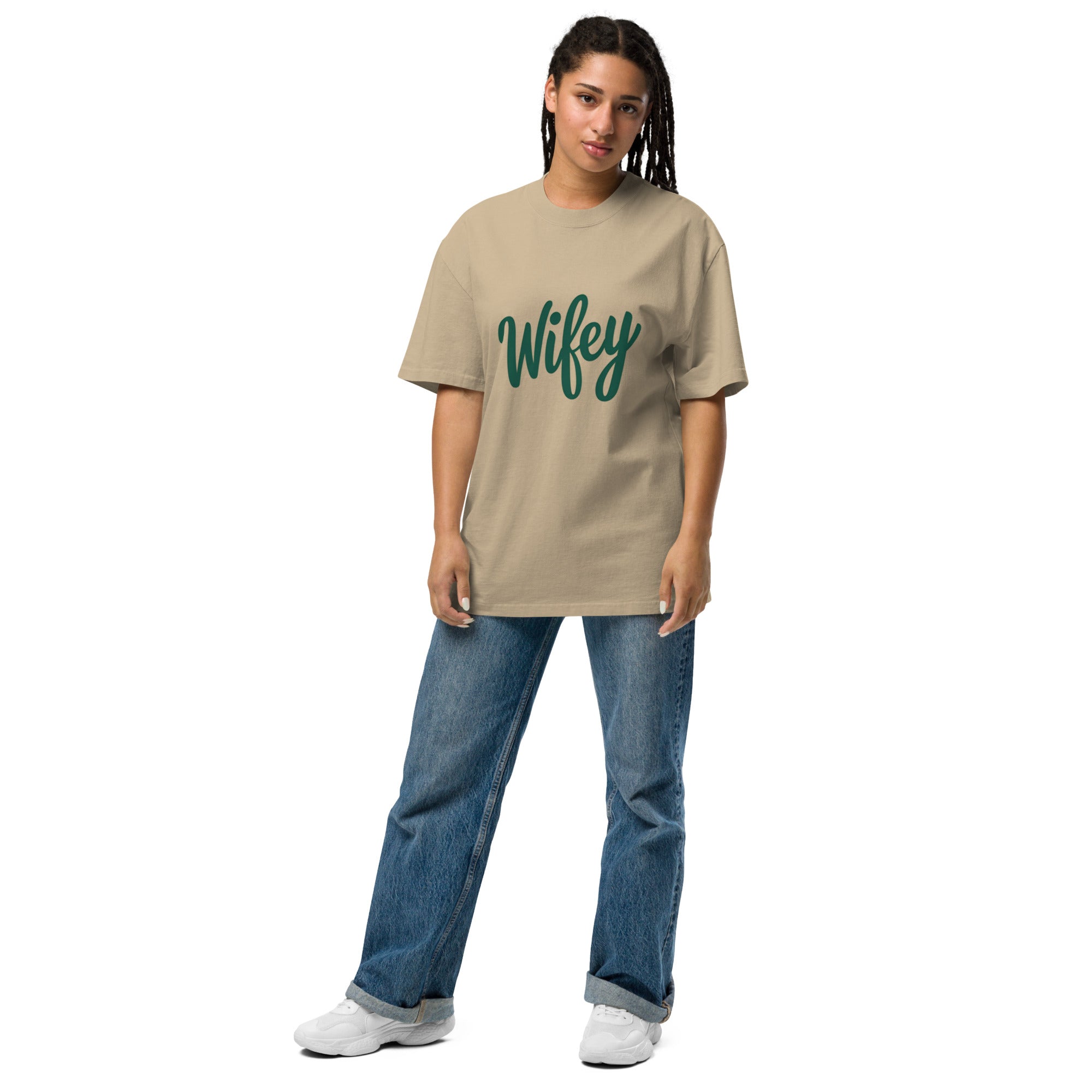 Person wearing a beige t-shirt with 'Wifey' printed in green on a white background