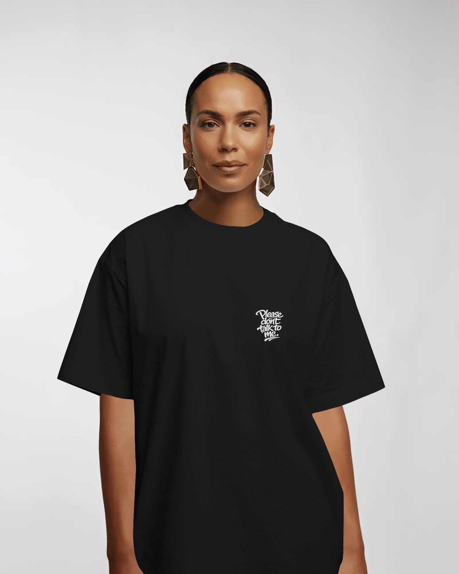 Model wearing a black oversized “Please Don’t Talk To Me” slogan t-shirt with relaxed fit and dropped shoulders, styled for everyday streetwear.