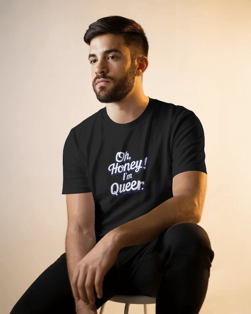 Man wearing a black t-shirt with 'Oh, Honey! I'm Queer' text on a beige background