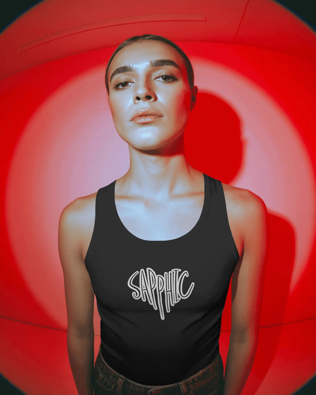 Person wearing a black tank top with 'Sapphic' text against a red circular background