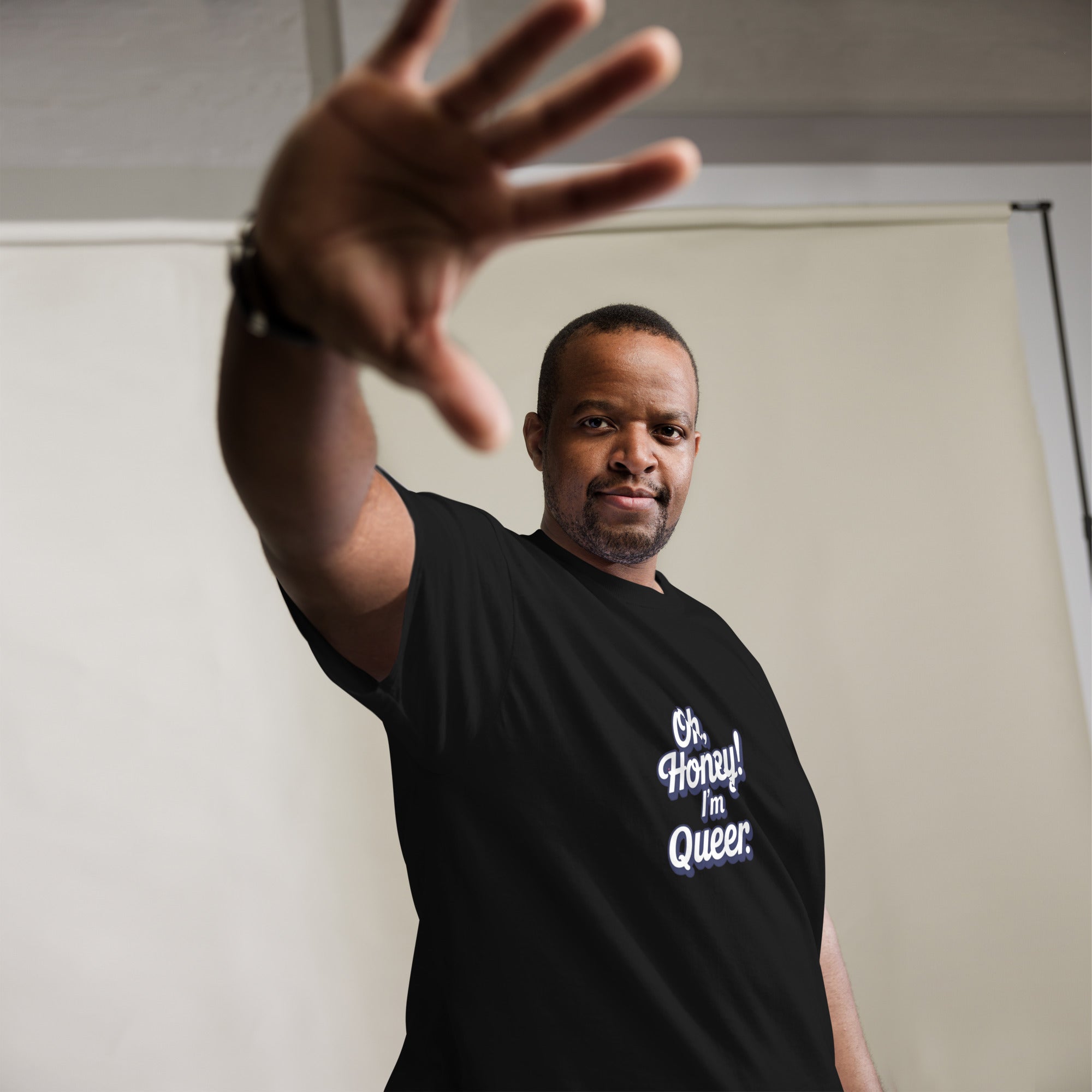 Man wearing a black t-shirt with text, making a gesture with his hand.