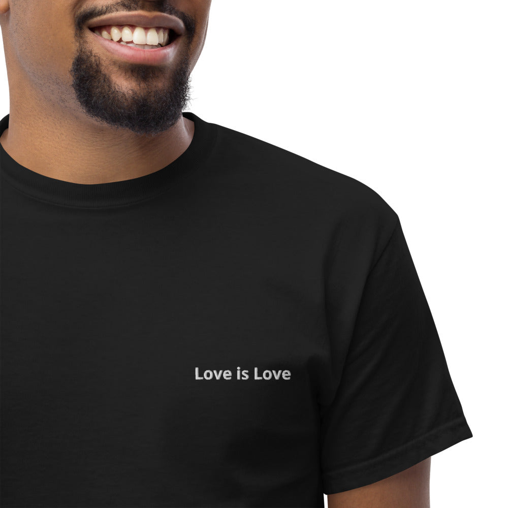Person wearing a black t-shirt with 'Love is Love' text on a white background