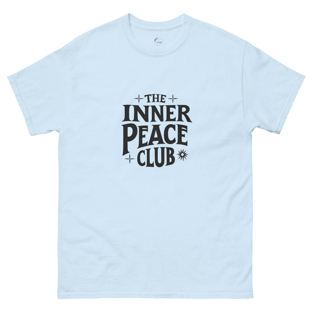 Flat lay of a cream-colored “The Inner Peace Club” t-shirt with soft lettering, styled with pastel accessories and cozy neutral tones.