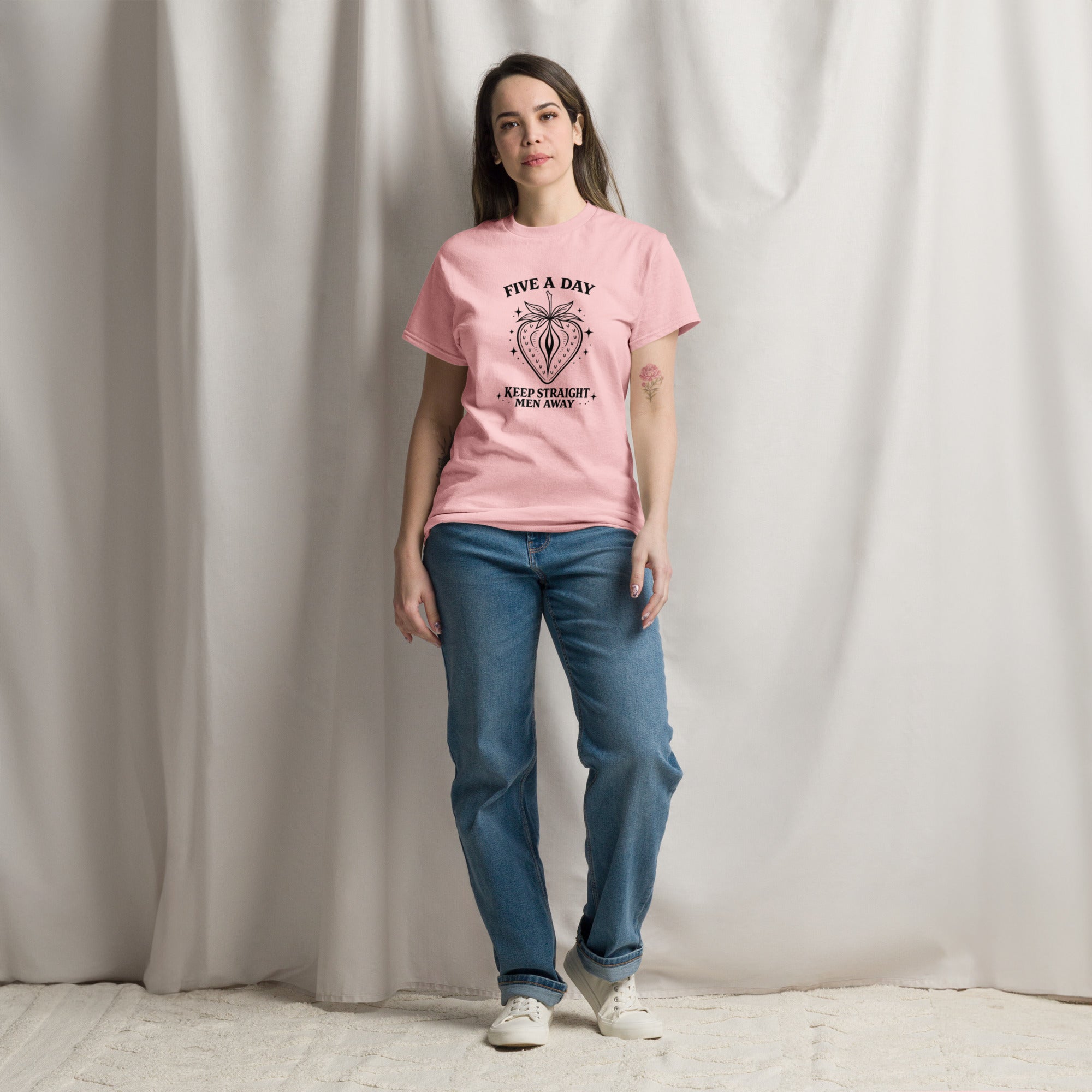 Person wearing a pink t-shirt with 'consistency is key' text against a plain background