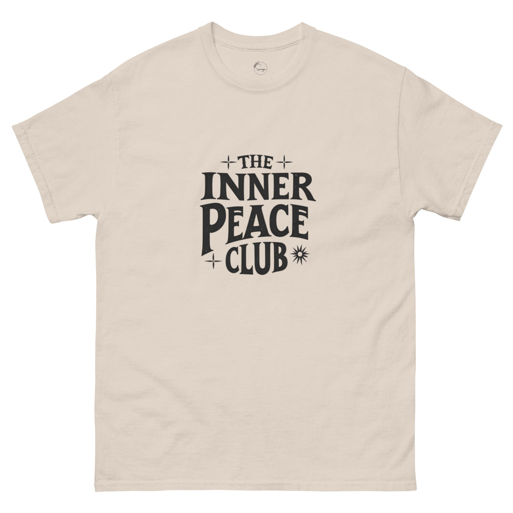 Flat lay of a cream-colored “The Inner Peace Club” t-shirt with soft lettering, styled with pastel accessories and cozy neutral tones.