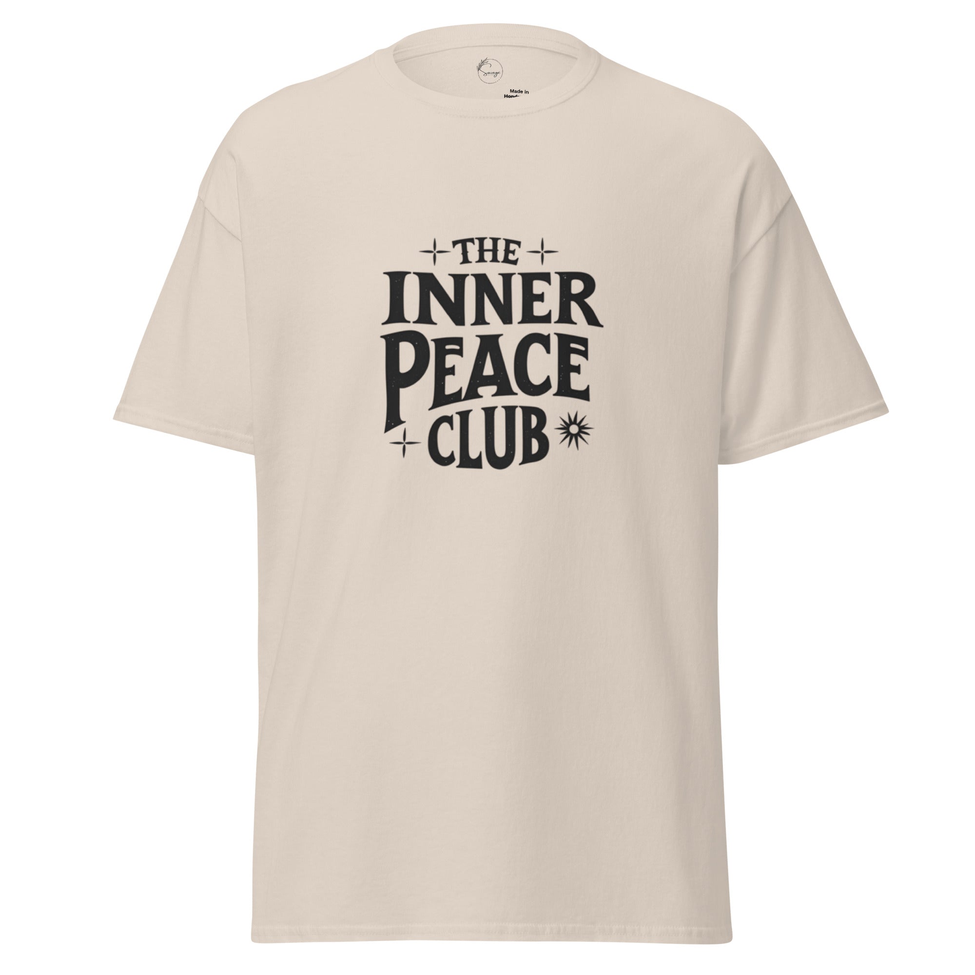 Flat lay of a cream-colored “The Inner Peace Club” t-shirt with soft lettering, styled with pastel accessories and cozy neutral tones.
