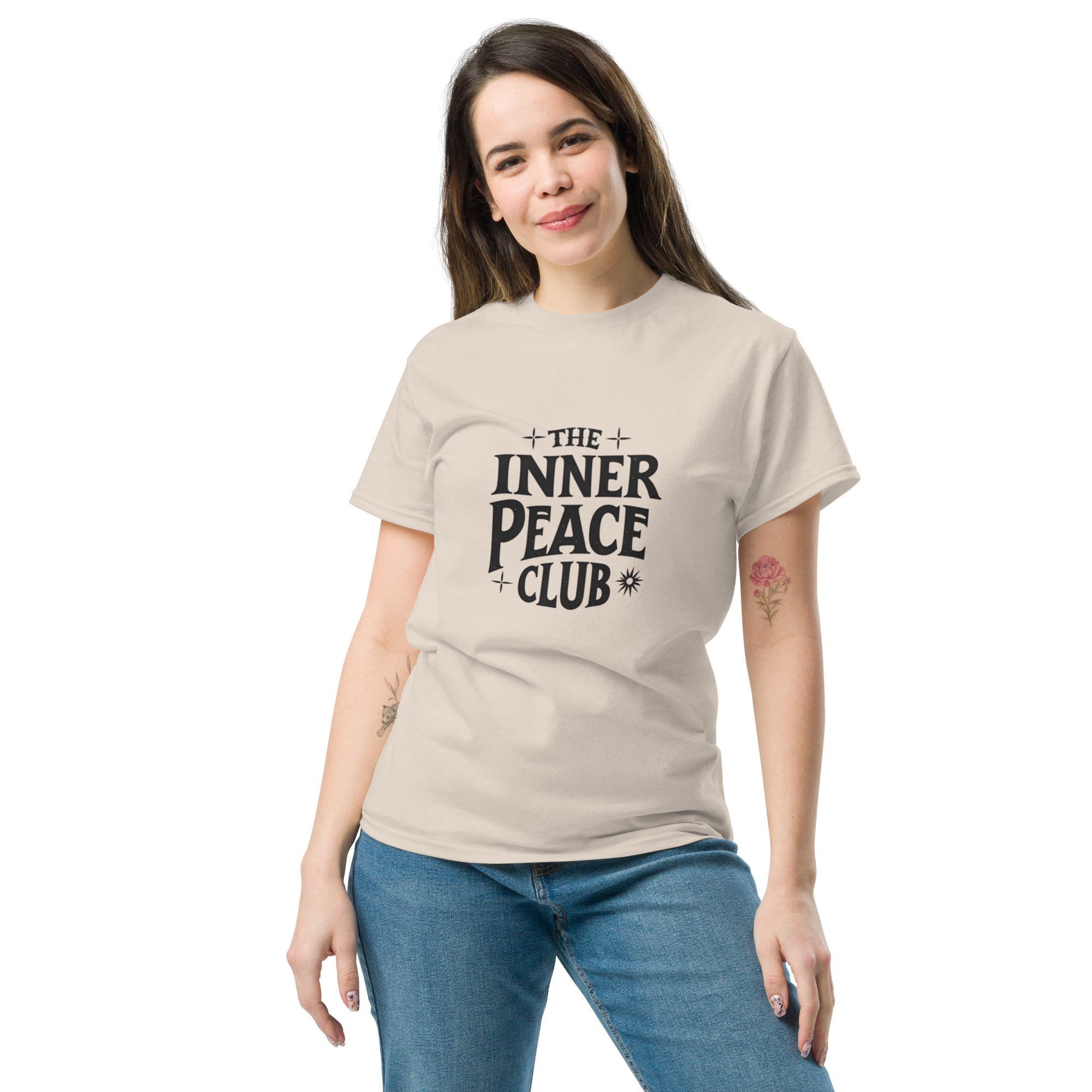 Flat lay of a cream-colored “The Inner Peace Club” t-shirt with soft lettering, styled with pastel accessories and cozy neutral tones.