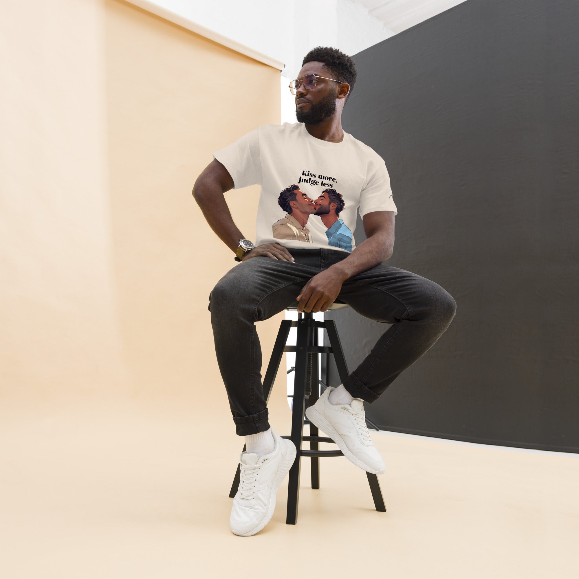 Man sitting on a stool wearing a t-shirt with a graphic design.