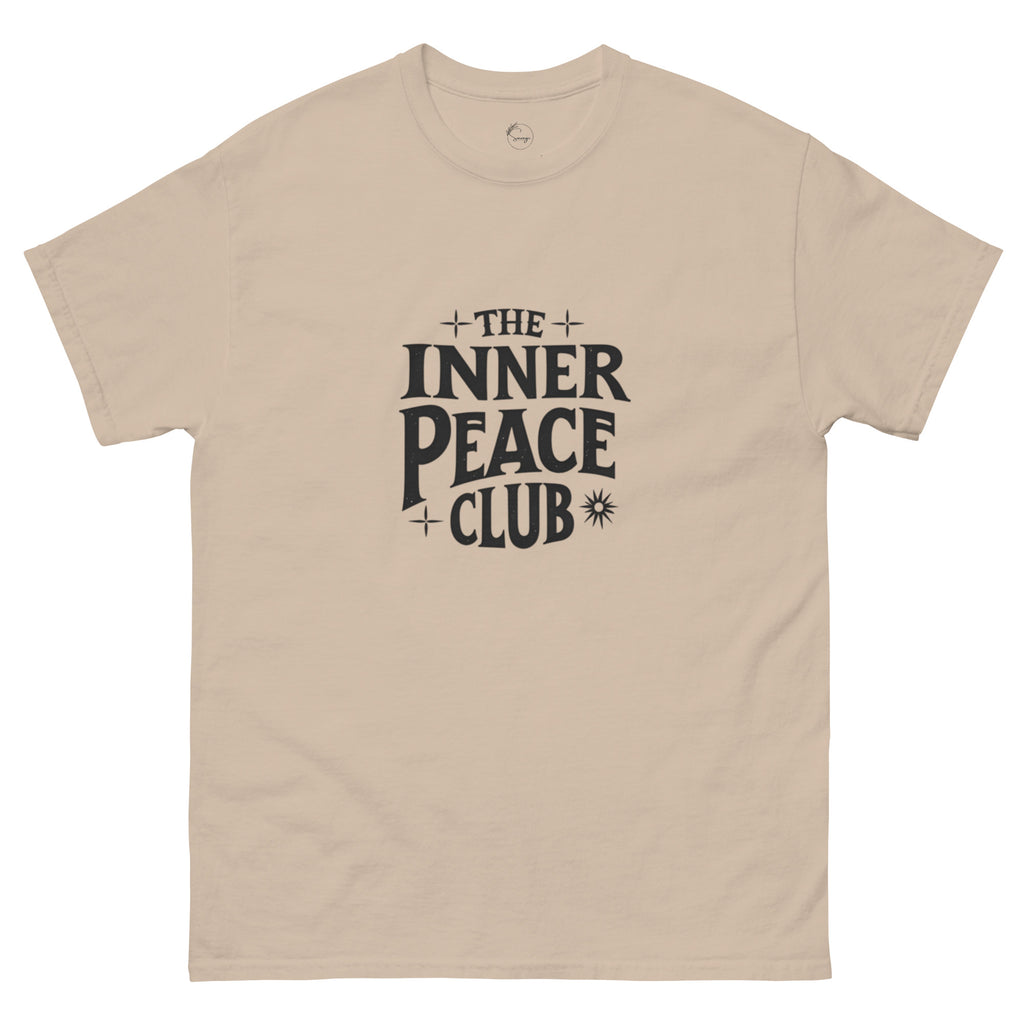 Flat lay of a cream-colored “The Inner Peace Club” t-shirt with soft lettering, styled with pastel accessories and cozy neutral tones.