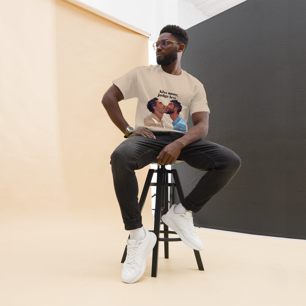 Man sitting on a stool wearing a t-shirt with a graphic design, against a plain background