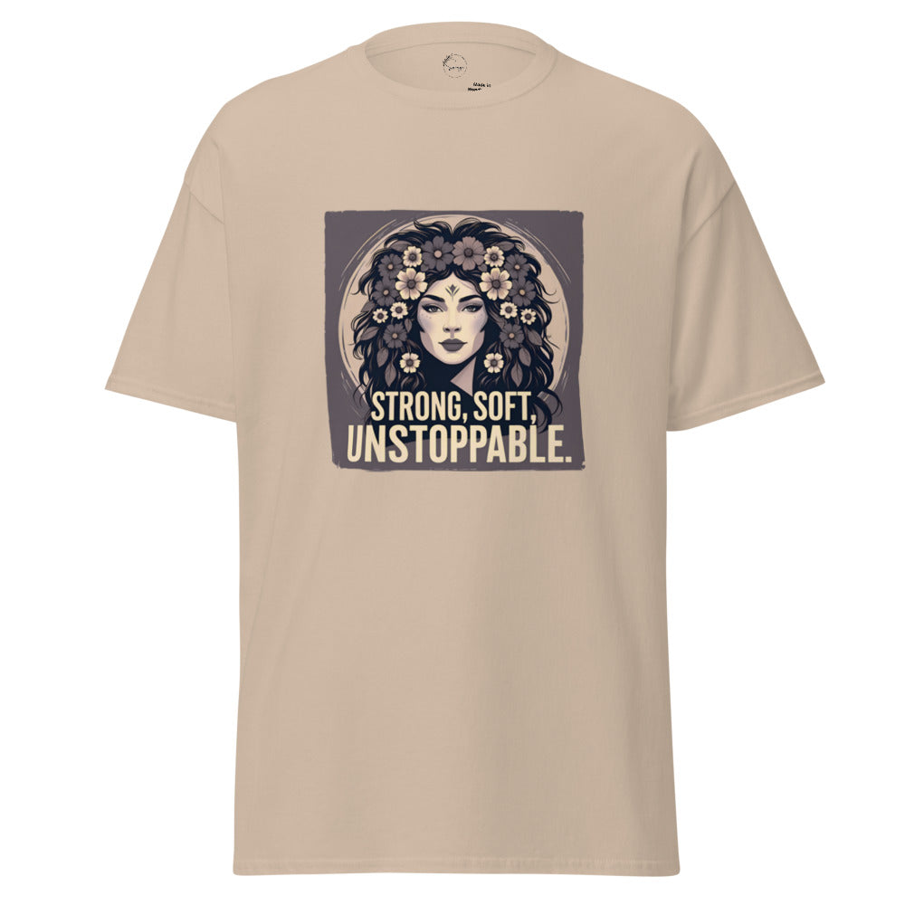 Beige t-shirt with a graphic of a woman with flowers and text 'STRONG, SOFT, UNSTOPPABLE' on a white background.